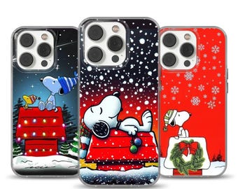 Può includere: Tre custodie per telefono con Snoopy in scene natalizie. Una custodia mostra Snoopy sulla sua cuccia con luci natalizie, un'altra Snoopy che dorme nella neve e la terza Snoopy con una ghirlanda. Le custodie hanno un bordo trasparente.