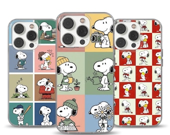 Puede incluir: Tres fundas para teléfono con diseños de Snoopy. Las fundas tienen bordes transparentes y un diseño de cuadrícula con ilustraciones de Snoopy. Una funda muestra a Snoopy con una cámara, otra a Snoopy leyendo y la tercera a Snoopy sobre un fondo a cuadros rojos y blancos.