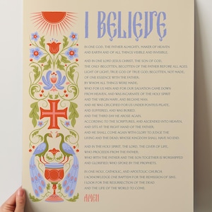 May include: A decorative poster with the text "I BELIEVE" in stylized lettering. The poster features a floral and bird design in red, blue, and green, with a cross and sun graphic.