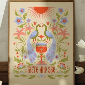 May include: A framed art print featuring a stylized illustration with two blue peacocks flanking a chalice. The artwork includes a red sun, floral elements, and the text "TASTE AND SEE" in red. The print is displayed on a wooden dresser.