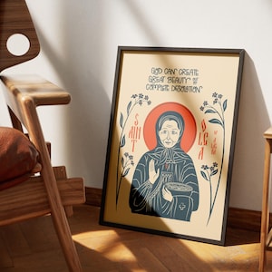 Puede incluir: Una l&aacute;mina enmarcada con una ilustraci&oacute;n estilizada de Santa Olga con t&uacute;nica azul oscuro y halo rojo. El texto dice: GOD CAN CREATE GREAT BEAUTY OUT OF COMPLETE DESOLATION. El dise&ntilde;o incluye detalles florales sobre un fondo de color crema.