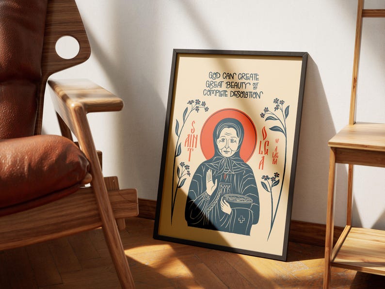 Puede incluir: Una l&aacute;mina enmarcada con una ilustraci&oacute;n estilizada de Santa Olga con t&uacute;nica azul oscuro y halo rojo. El texto dice: GOD CAN CREATE GREAT BEAUTY OUT OF COMPLETE DESOLATION. El dise&ntilde;o incluye detalles florales sobre un fondo de color crema.
