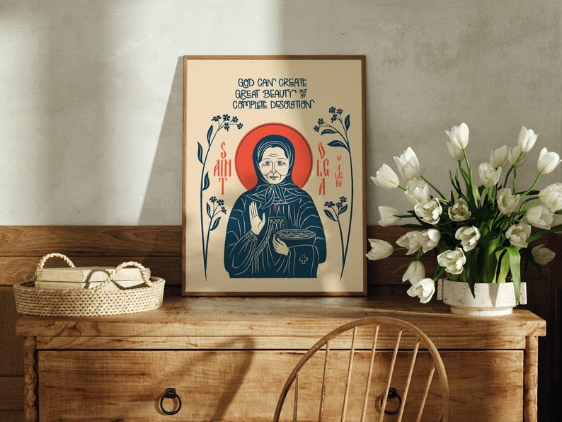 Puede incluir: Una l&aacute;mina rectangular sobre fondo crema con una ilustraci&oacute;n estilizada de una persona con pa&ntilde;uelo y halo rojo. El texto dice: GOD CAN CREATE GREAT BEAUTY OF COMPLETE DESOLATION. Tallos florales de color azul oscuro flanquean la figura central.