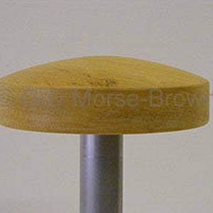 May include: A wooden knob with a rounded top, attached to a metal rod. The knob is light brown in color.