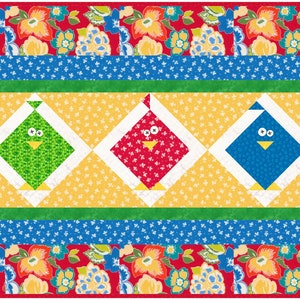 Op de afbeelding: Een kleurrijke, gestikte tafelrunner met een groen, rood en blauw vogelontwerp. De vogels bevinden zich in het midden van de runner, omringd door een gele achtergrond met witte stippen. De runner heeft een groene, blauwe en rode rand.