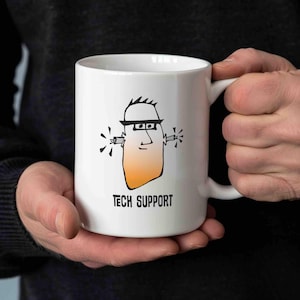Könnte beinhalten: Weiße Keramik-Tasse mit einer Cartoon-Illustration einer Person mit Schutzhelm, Schutzbrille und Ohrstöpseln. Das Gesicht der Person ist orange und der Text "TECH SUPPORT" ist darunter aufgedruckt.