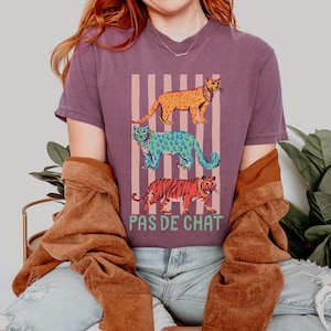 Camiseta Pas de Chat Ballet Cats | Gatos coloridos empilhados com frase em francês