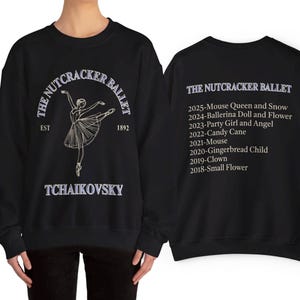 May include: Black sweatshirt featuring a ballerina graphic and the text "The Nutcracker Ballet" with the composer's name, Tchaikovsky. The back of the sweatshirt lists the ballet's performances from 2018 to 2025, including "Mouse Queen and Snow."
