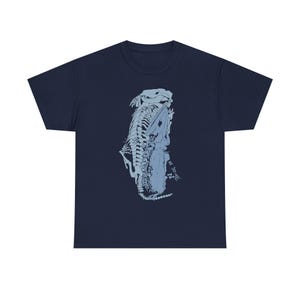 Puede incluir: Camiseta azul marino con una ilustración en azul claro de un esqueleto de reptil. El diseño gráfico está centrado en la parte delantera de la camiseta. La camiseta está hecha de un material suave y cómodo.