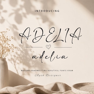 Può includere: Immagine promozionale per il font "Adelia". La parola "Introducing" è in alto, con "Adelia" in un elegante font script. Sotto, la parola "adelia" è ripetuta in uno script più piccolo. Il testo "Modern Handwriting Beautiful Fonts From Aysh Designer" è in basso.