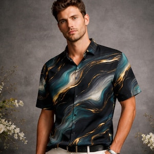 Może przedstawiać: Koszula z krótkim rękawem z wirującym wzorem w kolorze turkusowym, złotym i białym na czarnym tle. Koszula jest połączona z białymi spodniami i czarnym paskiem. Widoczny jest srebrny zegarek na rękę.