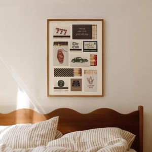 May include: A framed artwork featuring various matchbox designs. The designs include the number 777, text that reads "There are the good old days", a green car, and the words "Lucky You". The artwork hangs above a bed.