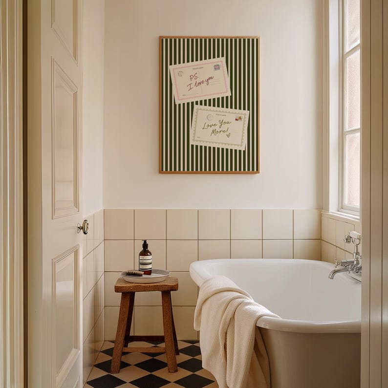 May include: A framed wall art piece with a black and white striped background and two postcards that read "PS I love you" and "Love You More!" in a bathroom setting. The bathroom has a white bathtub, a wooden stool, and a checkered floor.