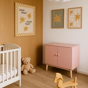 Puede incluir: Una habitaci&oacute;n infantil con una cuna blanca, un armario rosa y un caballito balanc&iacute;n de madera. El arte mural incluye una impresi&oacute;n enmarcada con el texto "GOOD NIGHT SLEEP TIGHT" e ilustraciones de estrellas. Un oso de peluche est&aacute; cerca de la cuna. Una l&aacute;mpara con forma de nube cuelga del techo.