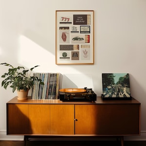 May include: A mid-century modern wooden cabinet with a record player, vinyl records, and a framed collage of vintage matchbooks. A potted plant sits on top. The album cover of The Beatles' Abbey Road is visible.
