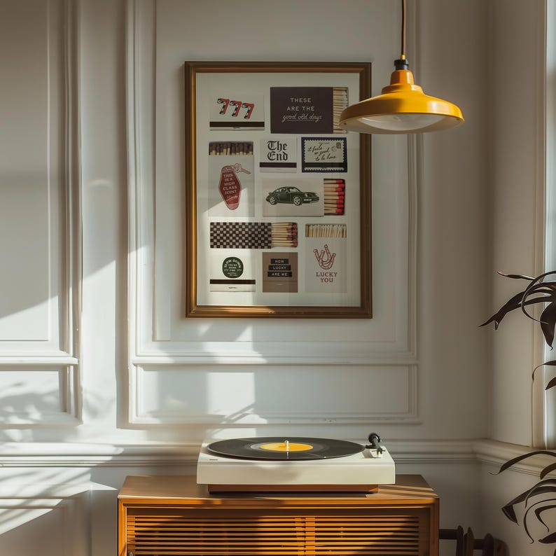 May include: A framed collage featuring various vintage-style images and text, including "777", "The End", and "Lucky You". A record player sits on a wooden cabinet below the artwork. A yellow pendant light hangs from the ceiling.