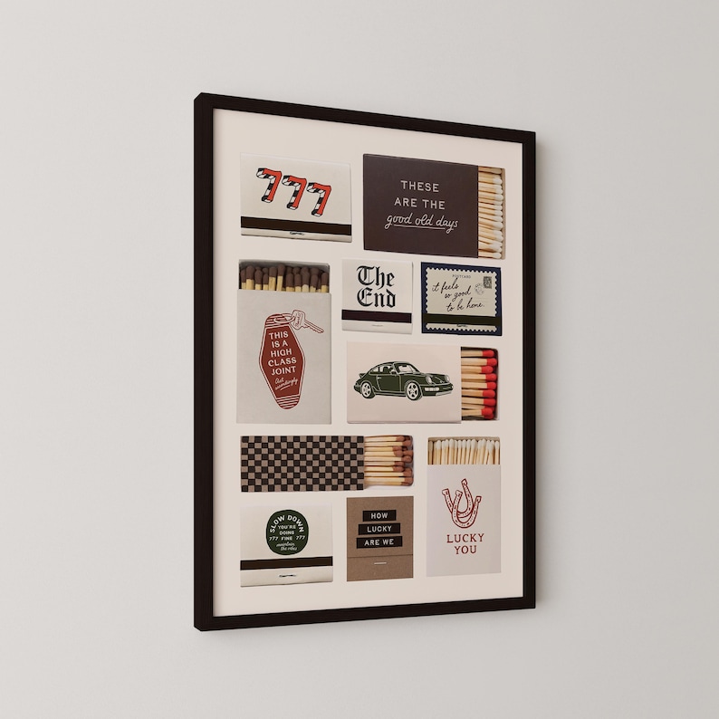 May include: A framed wall art print featuring a collage of various matchbox designs. The boxes display diverse graphics including the number 777, a vintage car, a horseshoe, and text such as 'These are the good old days' and 'This is a high class joint'.