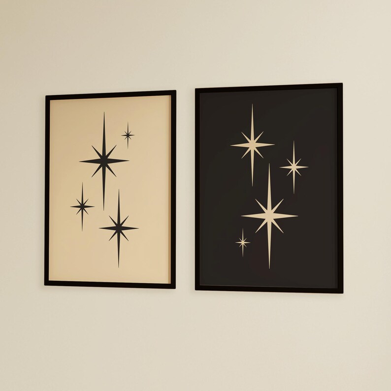 May include: Two framed art prints featuring a mid-century modern design. One print has a beige background with black starbursts, and the other has a black background with cream-colored starbursts. Both are in black frames.