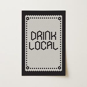 May include: A rectangular sign with a black border and a white interior composed of small, hexagonal tiles. The words "DRINK LOCAL" are spelled out in black letters. The sign is on a white background.
