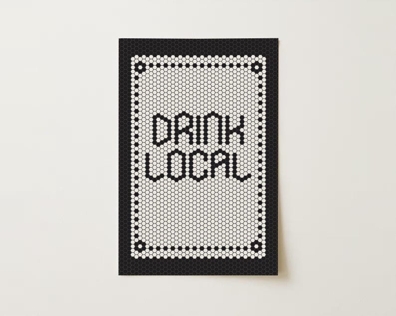 May include: A rectangular sign with a black border and a white interior composed of small, hexagonal tiles. The words "DRINK LOCAL" are spelled out in black letters. The sign is on a white background.