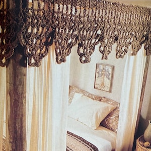 May include: A wooden bed frame with a crocheted canopy and white curtains. The bed is made with a patterned blanket and pillows. A wicker side table with a pitcher and fruit sits next to the bed.