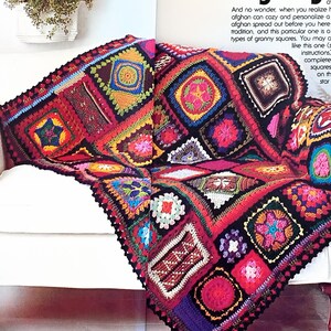 Peut inclure: Une couverture afghane faite à la main, colorée, drapée sur un fauteuil blanc. L'afghan présente un motif patchwork avec divers motifs carrés dans des tons de rouge, rose, jaune et bleu. Le mot "Afghans" est visible.