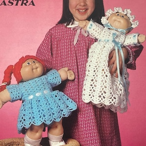 May include: A vintage crochet pattern cover featuring a young girl holding two crocheted dolls. The dolls are dressed in blue and white crochet outfits. The cover reads "Patons" and "Take me to Grandma's". The pattern is for "BEEHIVE ASTRA" crochet.