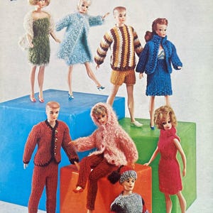 May include: Vintage advertisement featuring dolls dressed in knitted outfits. The dolls are posed on colorful blocks, showcasing various knitted sweaters, dresses, and suits. The text "Just for Dolls" and the Patons and Beehive logos are visible.