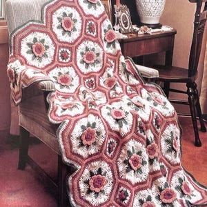 May include: A crocheted afghan in soft colors, featuring octagons and squares with raised flower and popcorn stitch details. The afghan is draped over a chair. The text "4 Queen Anne's Bouquet" is visible.