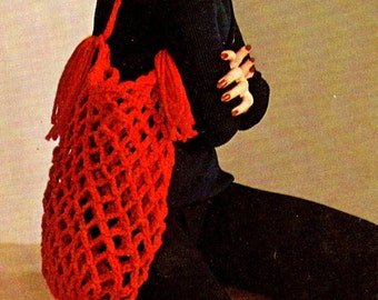 May include: A red crocheted tote bag with fringe. The bag has a geometric pattern and is being worn by a woman with a multi-coloured crocheted hat.