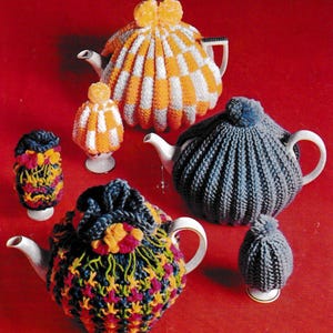 Puede incluir: Una colección de teteras de punto en varios diseños y colores. Las teteras incluyen cuadros naranjas y blancos, azules con un pompón y un estampado floral multicolor. Las teteras se exhiben en teteras blancas y una huevera.
