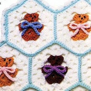 May include: Close-up of a crocheted blanket with a honeycomb pattern. Each hexagon features a small teddy bear with a bow. The bears are in shades of brown and the bows are blue, pink, and purple. The border is light blue.