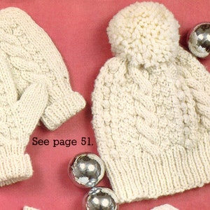 Könnte beinhalten: Eine weiße Strickmütze mit Bommel und dazu passende Fäustlinge. Mütze und Fäustlinge haben ein Zopfmuster. Siehe Seite 51.