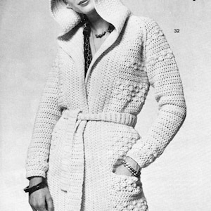 May include: A white crocheted hooded cardigan with a belt and pockets. The cardigan is shown on a model. The text "Cool Weather Cover-Up" and "32" are visible in the image.