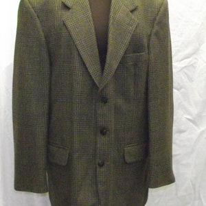 Può includere: Un blazer a quadri marroni e grigi con chiusura a tre bottoni.