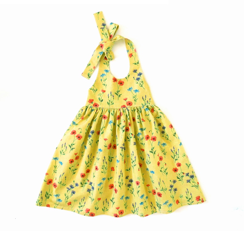 May include: A yellow sleeveless dress with a halter neckline and a floral print featuring red poppies and blue flowers.