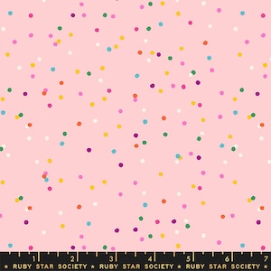 Peut inclure: Tissu rose avec un motif de confettis composé de petits points colorés dans différentes nuances de rose, jaune, orange, vert, bleu et violet.