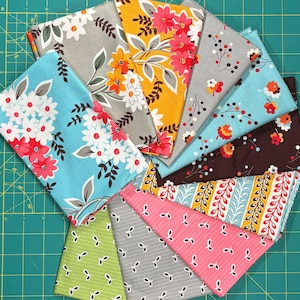 Peut inclure: Un assortiment de carrés de tissu pliés avec divers motifs floraux et botaniques. Les tissus présentent des motifs de marguerites, de feuilles et d'autres éléments floraux dans des couleurs telles que le bleu, le gris, le jaune, le marron et le rose.