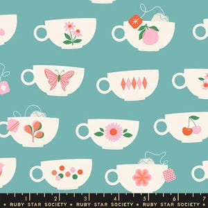 May include: A teal fabric featuring a repeating pattern of cream-colored teacups decorated with various motifs including flowers, butterflies, cherries, and tea bags. A black ruler at the bottom shows measurements in inches.