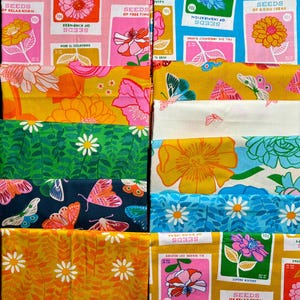 May include: A collection of folded fabric swatches featuring vibrant patterns. Designs include vintage-style seed packets with floral illustrations, colourful butterflies on mustard yellow, white, and dark navy backgrounds, and daisy floral prints.