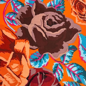 May include: Vibrant fabric featuring large, stylized roses in shades of brown, red, and peach against a bright orange background. The design includes blue and pink leaves. The text "Fassett For Rowan. #GP-95 Russian Rose" is visible.