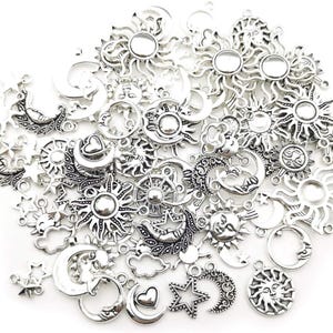 May include: A collection of silver-toned charms featuring celestial designs. The charms include suns, moons, stars, and clouds. These small metal charms are ideal for jewelry making or other craft projects.