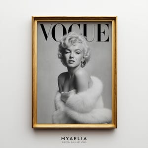 Può includere: Una stampa artistica da parete incorniciata in bianco e nero che raffigura un ritratto di Marilyn Monroe con una stola di pelliccia bianca, con la parola VOGUE stampata in grandi lettere nere in alto. La stampa è in una cornice dorata metallica.