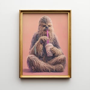 May include: A framed art print featuring a Chewbacca-like character enjoying a bubble tea. The character is depicted with brown fur, holding a cup with a pink straw. The background is a solid peach color, and the frame is gold.