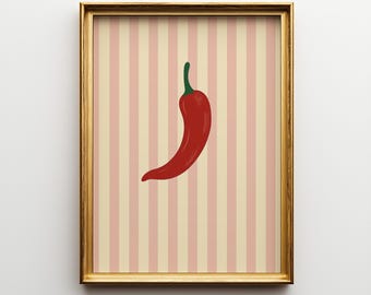 May include: A framed art print depicting a red chilli pepper with a green stem set against a striped backdrop of pink and cream. The frame is gold. The artwork is a food-themed illustration, suitable for a kitchen or dining area.