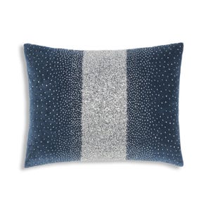 Puede incluir: Una almohada de terciopelo azul con una franja plateada en el centro. La almohada está cubierta de pequeñas lentejuelas plateadas.