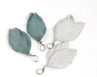 Suede leather feather earrings in smoky blue and in light grey. Set of two