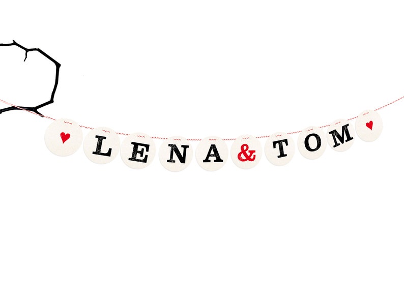 May include: A white banner with red hearts and black lettering that reads "Lena & Tom".