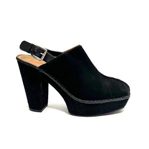 May include: Black suede platform heeled sandals with a slingback strap and a buckle closure.