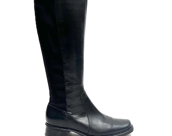 May include: Black leather knee-high boots with a low block heel. The boots have a pointed toe and a zipper on the inside of the shaft.
